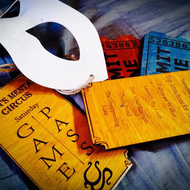 Phantom of the Big Top escape room: a white mask on Ella's Mental Circus game passes and admit-one tickets